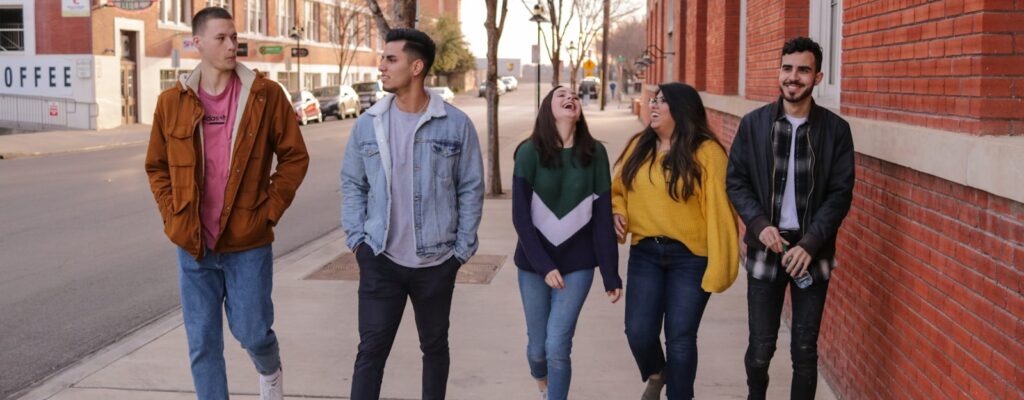 three men and laughing two women walking side by side